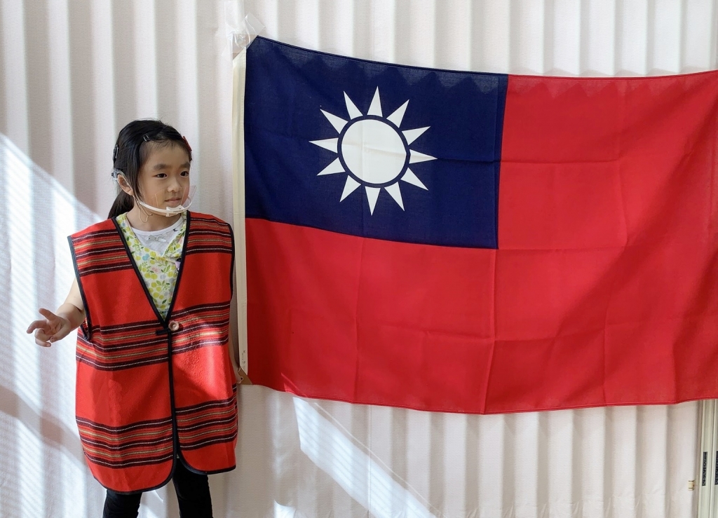 台湾の国旗の前でポーズ