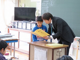 通知票を一人ずつ渡しています