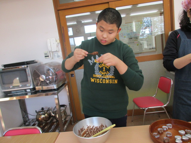 チョコレートを型に流しています。