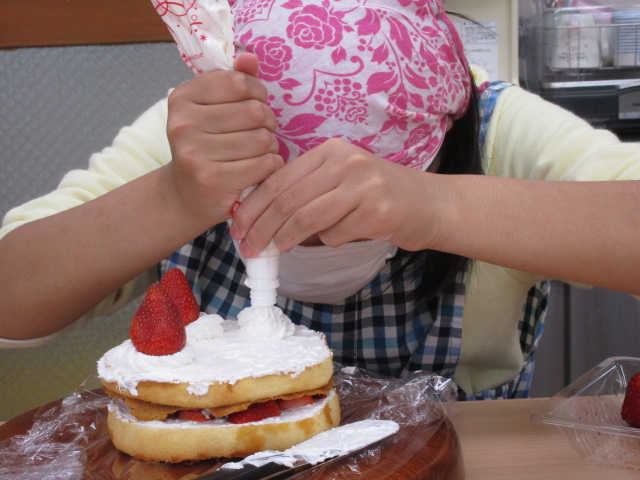 ケーキにクリームをたっぷり載せています。
