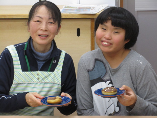 おいしそうなドーナツを前に舎生と職員のツーショット