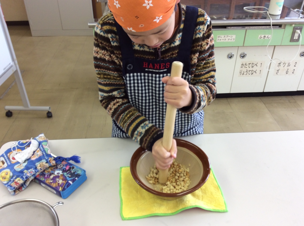大豆をすりばちとすりこぎですりつぶしてる様子