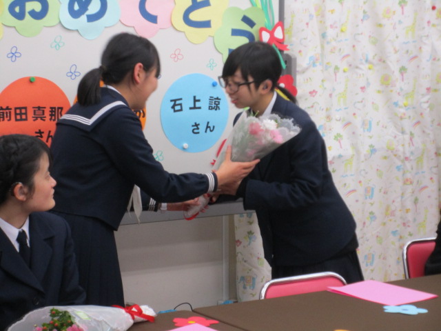 卒業生に花束を渡す女子