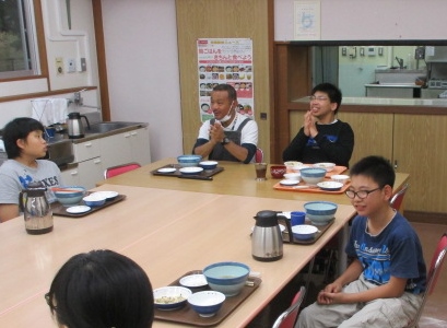 みんなで夕食を食べながら、誕生日のお祝いをしている写真です。
