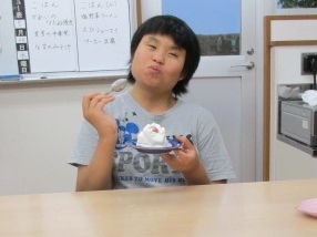 「美味しいな」と笑顔でケーキを食べている写真です。