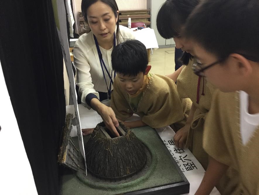 竪穴住居のレプリカを観察している様子