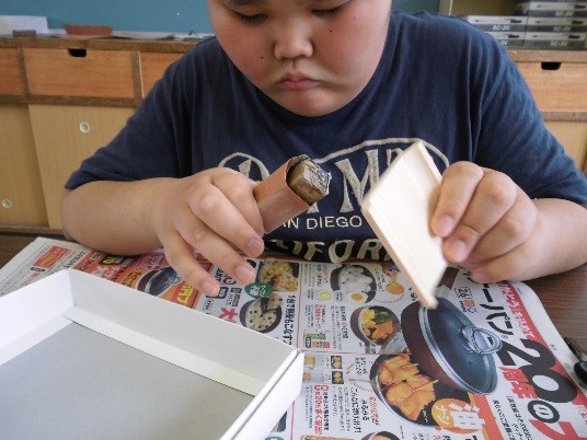 紙やすりで皿を削る生徒