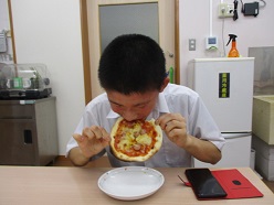 ピザにかぶりつく舎生