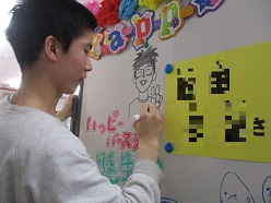 ホワイトボードに似顔絵を描く舎生