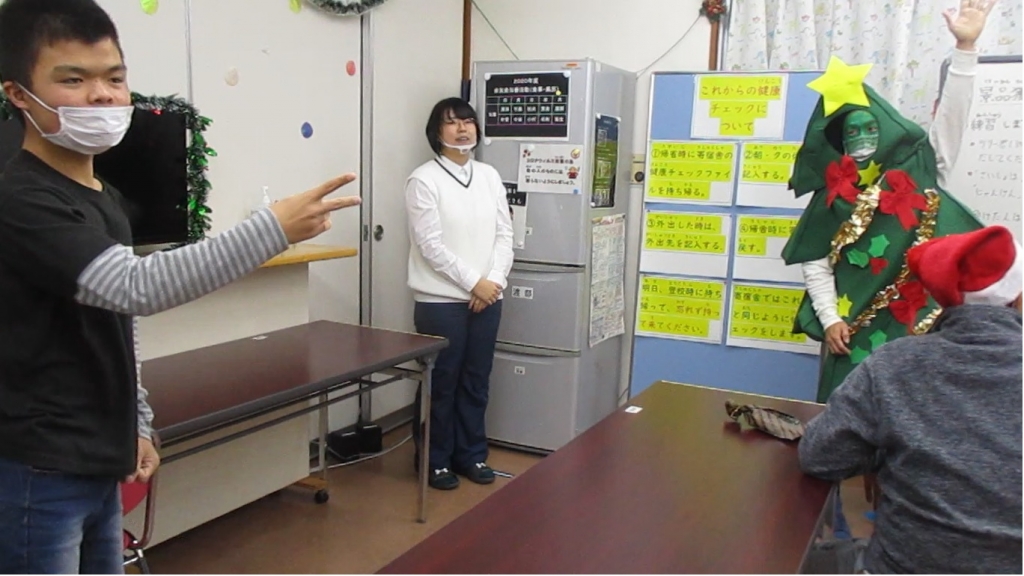 舎生がツリーの着ぐるみを着た職員とじゃんけんをしている写真その１