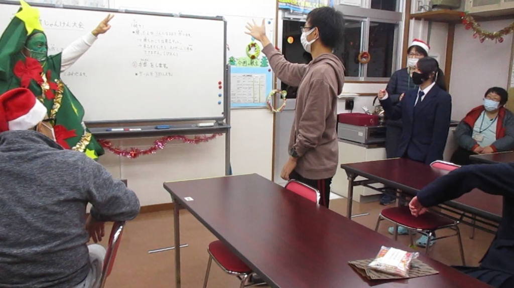 舎生がツリーの着ぐるみを着た職員とじゃんけんをしている写真その２