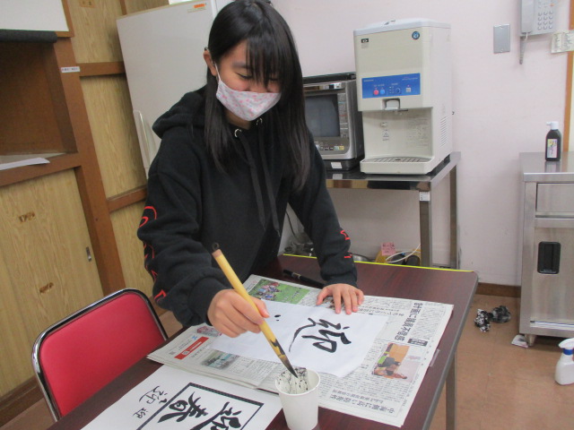 迎春を筆で書く聾生