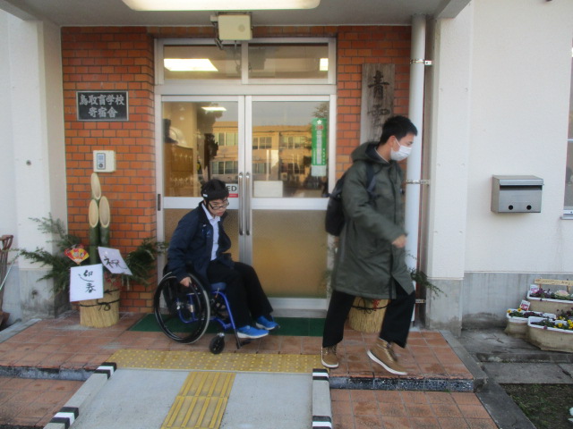 玄関を出発する盲生２人