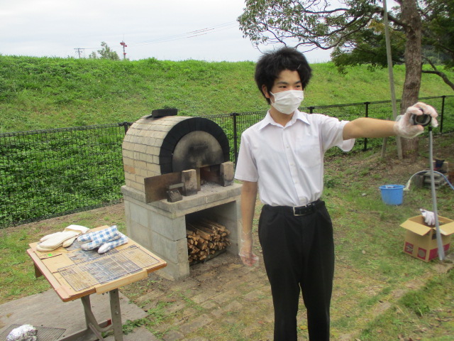 石窯で焼き時間を計る舎生
