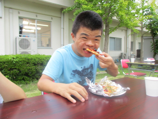 ピザを美味しそうに食べる舎生