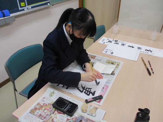 女子舎生が「勇往邁進」と書いている様子
