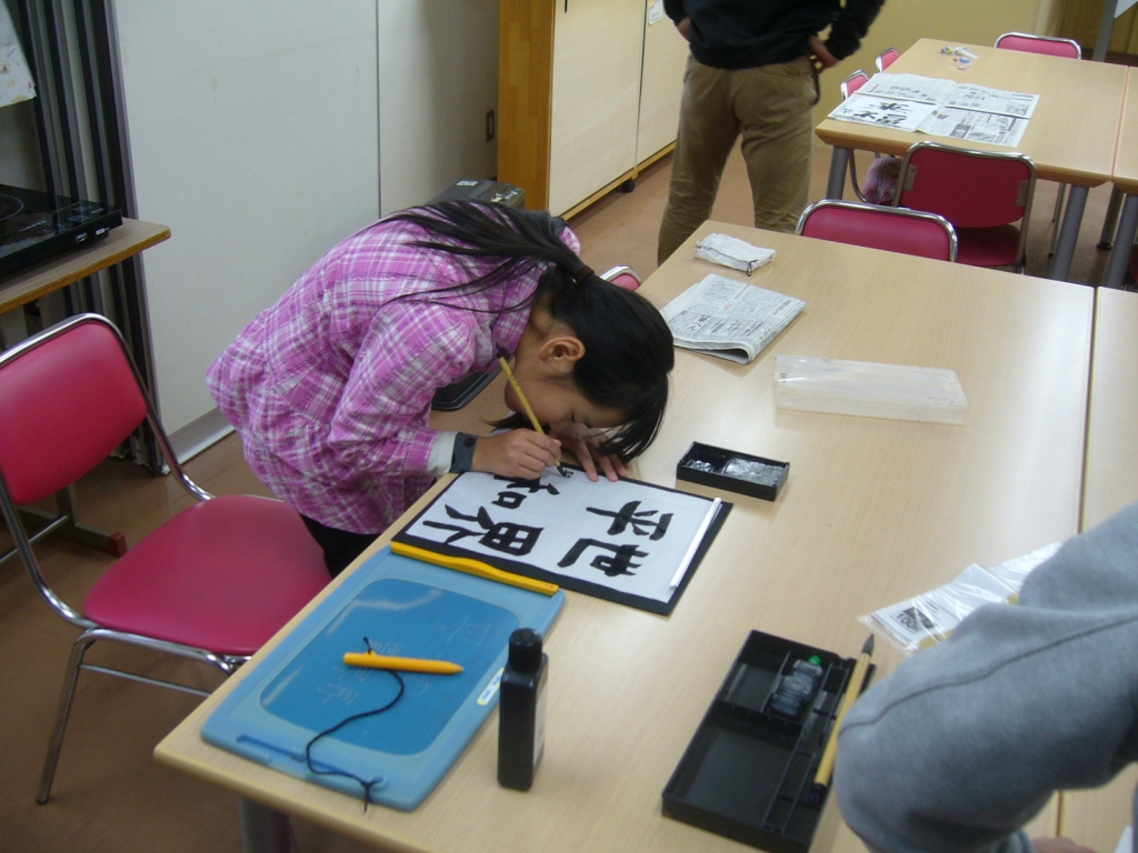 盲生女子が書き初めを書くようす