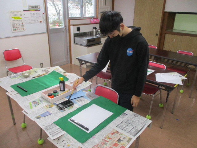 食堂で書初めをする男子舎生①