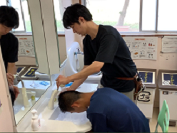 舎生が講師に洗髪してもらう様子