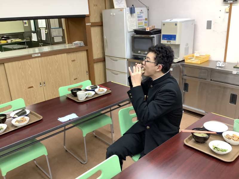 恵方巻を丸かぶりする舎生C