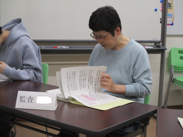 舎生が総会資料を見て確認している様子