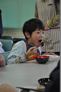 もちをおいしそうに食べる児童