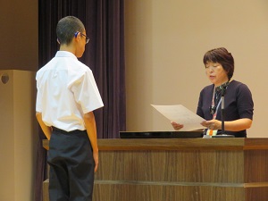 スポーツ大会の卓球部門で入賞した生徒が賞状が渡させる様子。