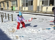 スコップで雪を持ち上げる